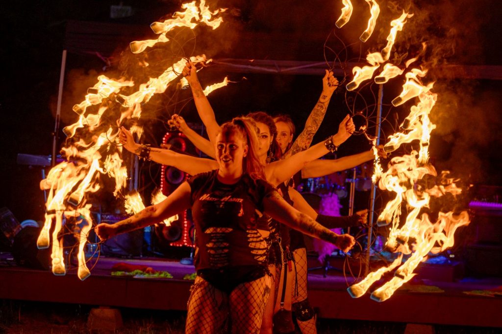 2024 Durational Performers: Nasty Habitz rock neo burlesque troupe, lined up with fire fans.