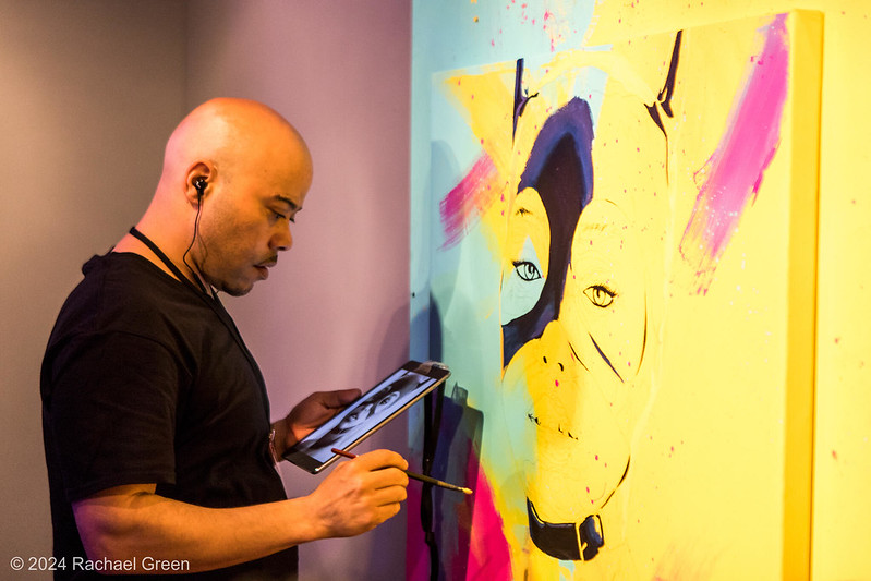 Artist Myron Curry painting a mural at SEAF 2024